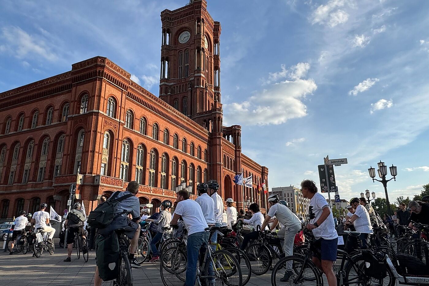 in weiß gekleidete Radfahrende vor dem Roten Rathaus