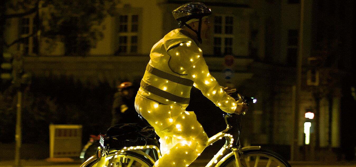 Mensch auf Fahrrad mit Lichterketten