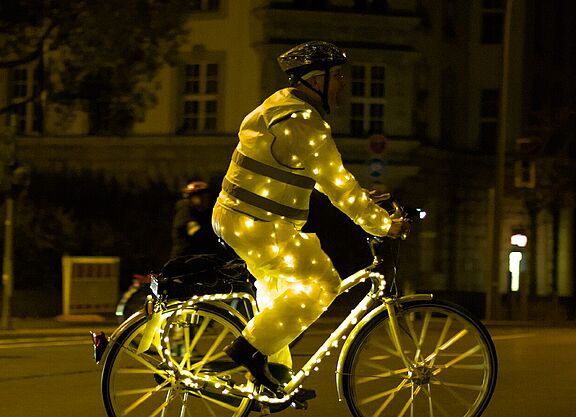 Mensch auf Fahrrad mit Lichterketten
