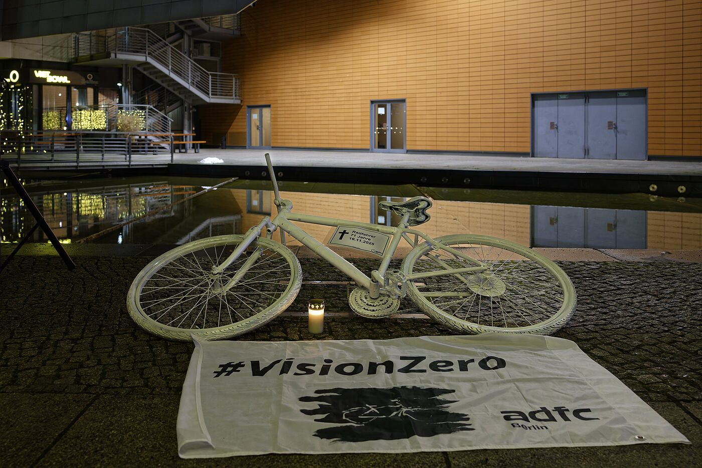 Geisterrad 24.11.2025 Mitte Ein weißes Geisterrad liegt hinter einer weißen Vision Zero Fahne