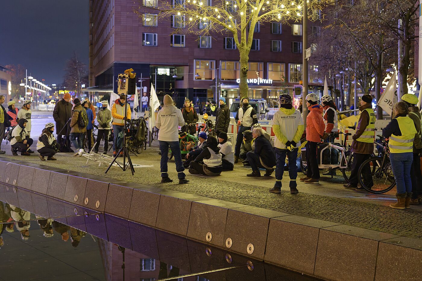 Geisterrad 24.11.2025 Mitte Menschen mit Warnwesten stehen bei einer Mahnwache