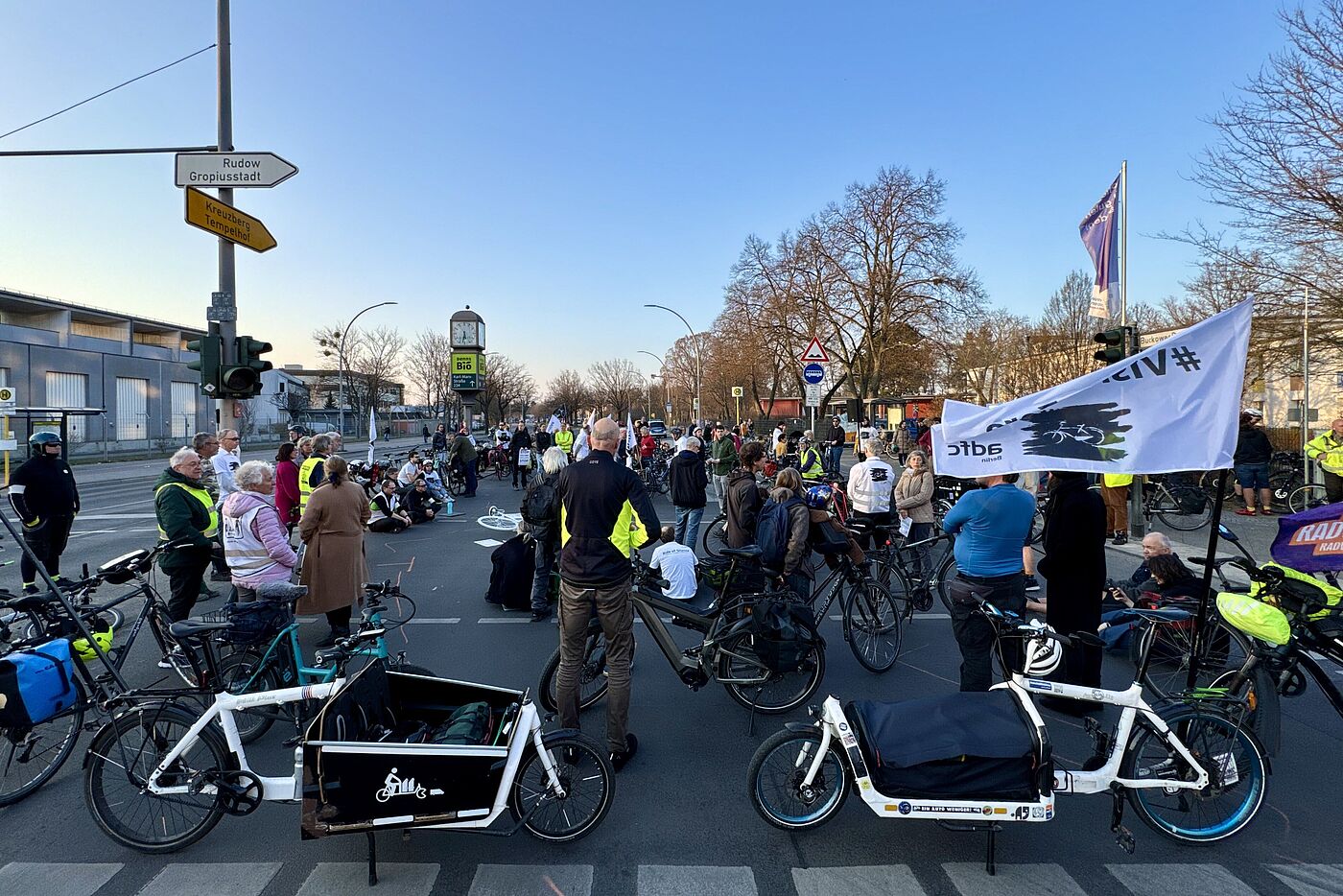 Menschen stehen für eine Mahnwache auf der Straße, Vision Zero Fahne im Vordergrund